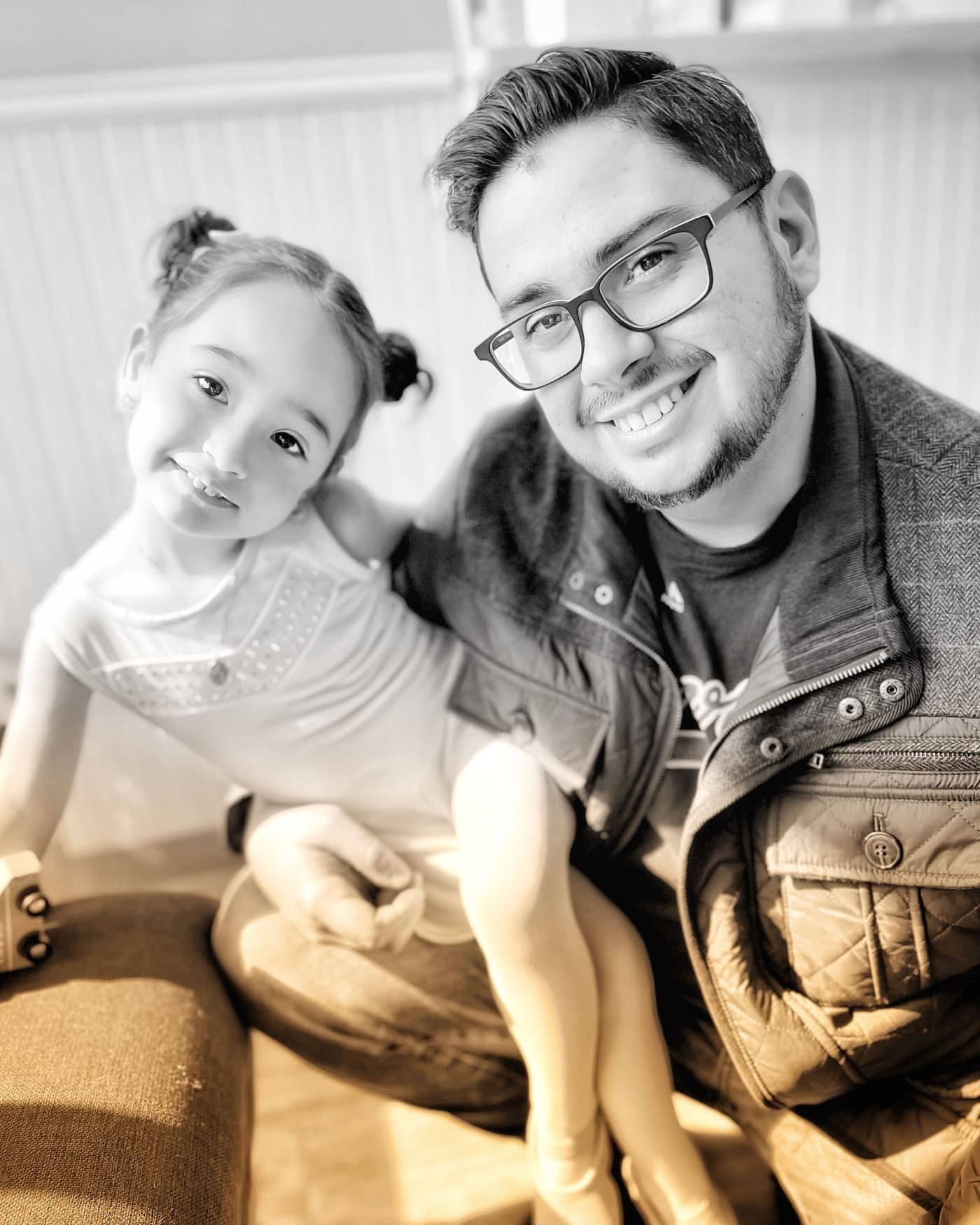 The photographer and daughter smiling together, in warm black and white.